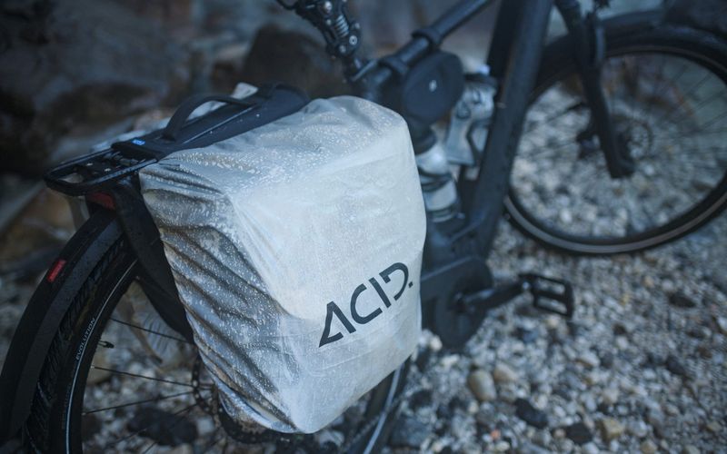 Fahrrad mit abgedeckter Gepäcktasche auf einem Schotterweg