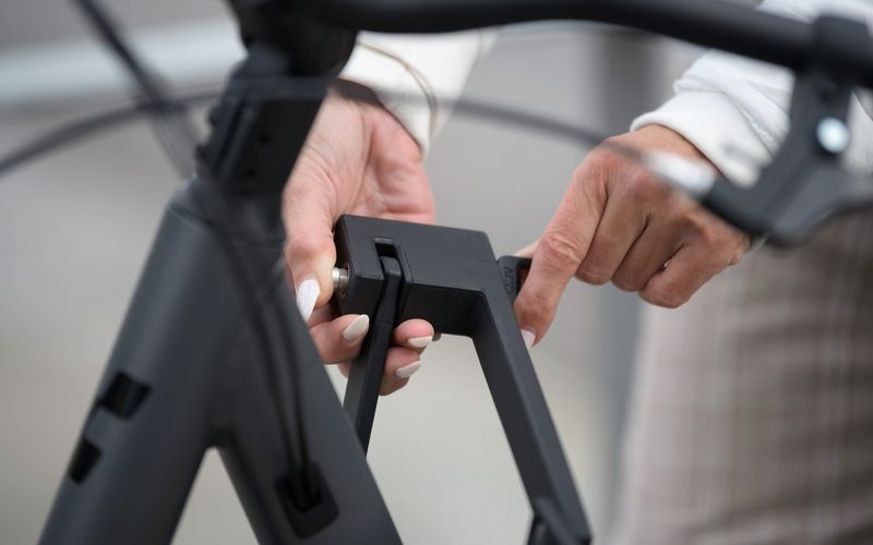 Hände legen ein aufgeklapptes Faltschloss an den Rahmen eines CUBE Bikes