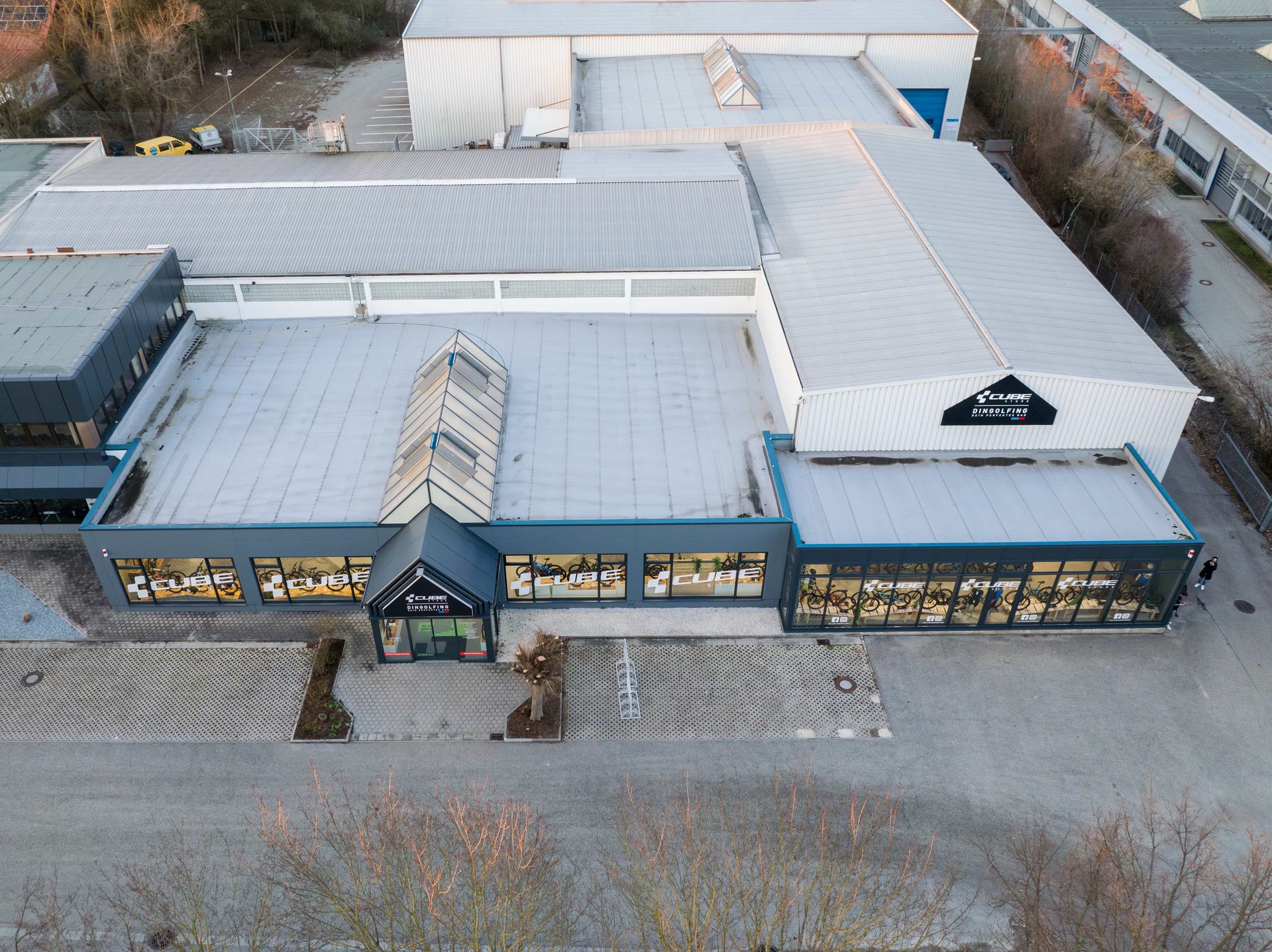 Luftaufnahme des CUBE Store Dingolfing mit Eingang und Schaufensterfront