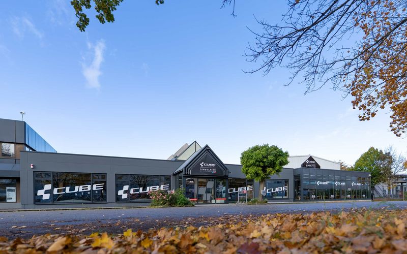 Außenansicht des CUBE Store Dingolfing mit CUBE Schriftzug an der Fassade