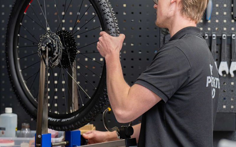 Mechaniker zentriert ein Laufrad im Zentrierständer