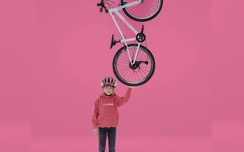 Kind hält ein CUBE Kinderrad hoch